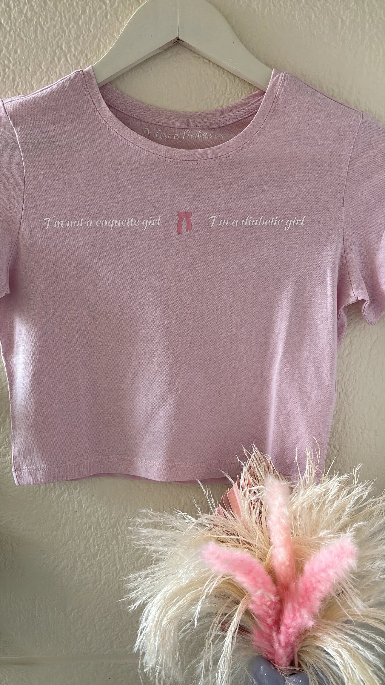 camiseta cropped con la frase I'm not a coquette girl I'm a diabetic girl estampada en el pecho con un lazo