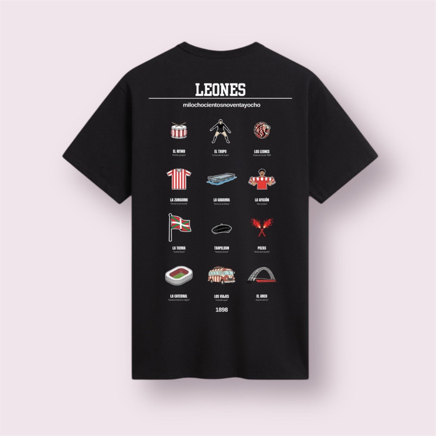 Camiseta negra edición 'Leones 1898' vista trasera. Diseño exclusivo de moda casual para aficionados del Athletic Club que celebra su filosofía única. Incluye iconos ilustrados históricos: La mítica Gabarra, 'El Txopo' Iribar, el Arco de San Mamés, el ambiente de la calle Pozas y la Ikurriña. La prenda perfecta para vestir el sentimiento zurigorri y la tradición de 1898.