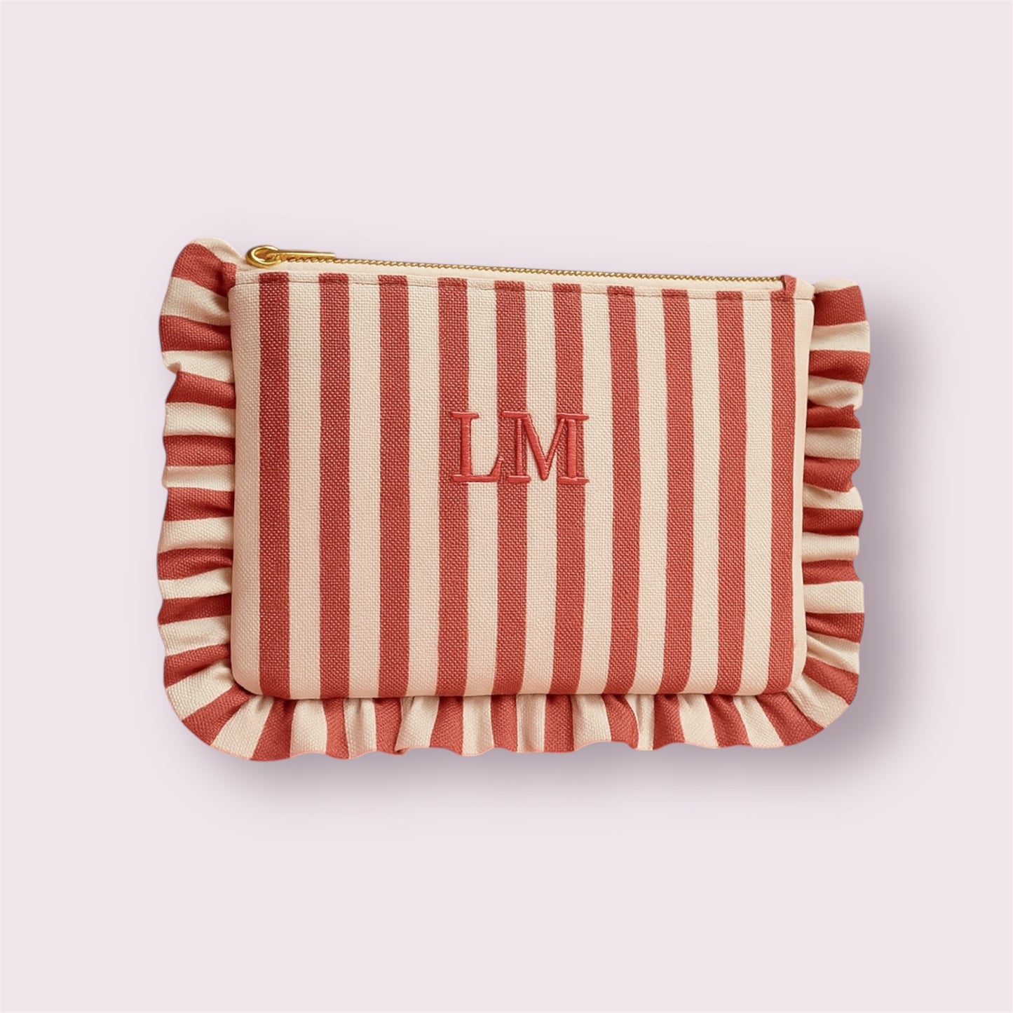 Funda personalizada de rayas rojas con flecos y bordado de iniciales LM, hecha a mano por Aroa Dedales