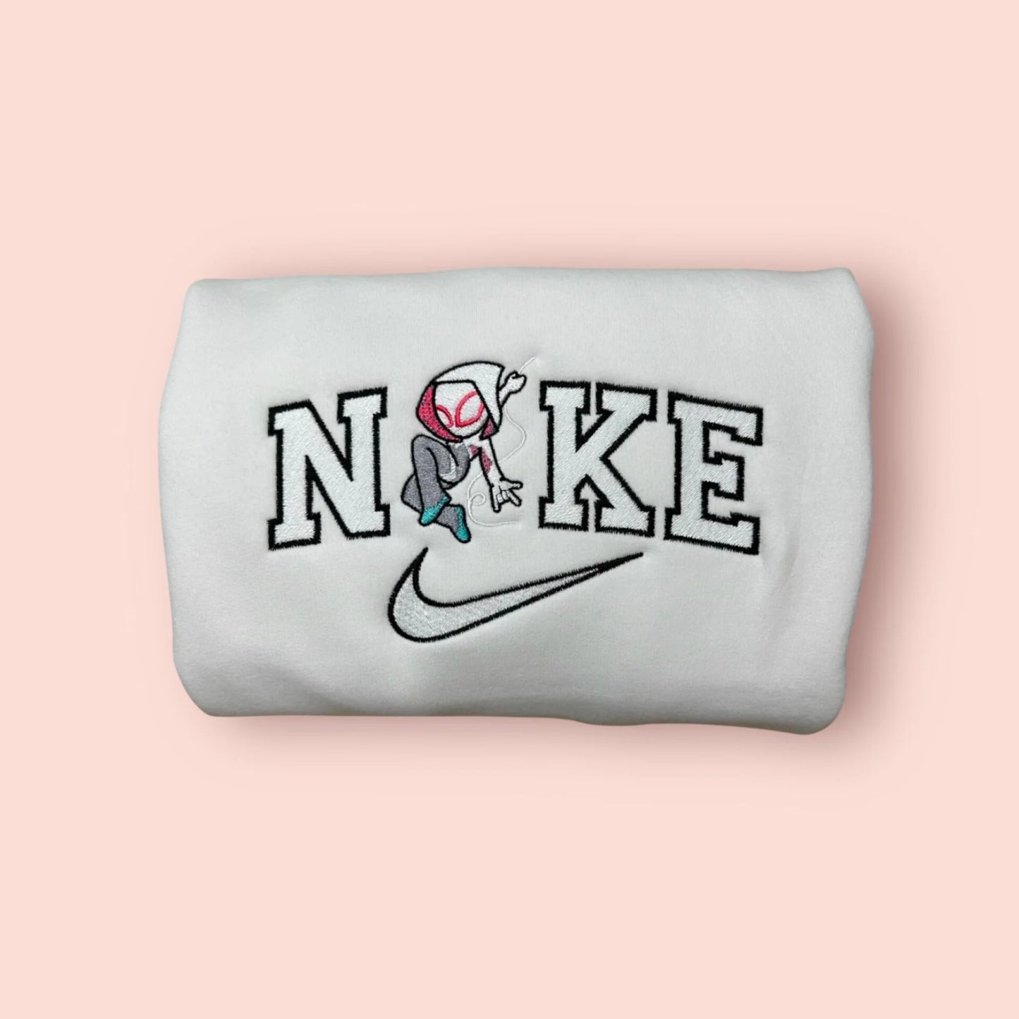 Sudadera blanca de algodón con un bordado exclusivo de Spider-Gwen (Ghost-Spider). El diseño captura la agilidad del personaje de "Across the Spider-Verse" con su capucha y traje característicos, integrado en letras estilo universitario. Ropa personalizada de Marvel, ideal para regalar a tu novia o fan del Spider-Verse. Combínala con la sudadera de Spider-Man para crear el 'matching outfit' que desafía cualquier evento canónico.