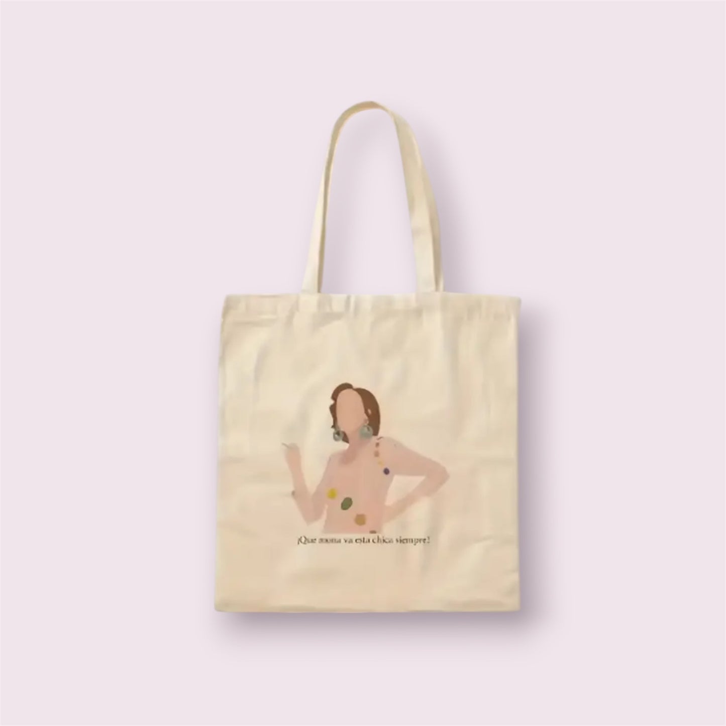Tote bag de algodón natural con ilustración y frase icónica 'Qué mona va esta chica siempre', inspirada en la serie Aquí no hay quien viva. Diseño divertido y nostálgico ideal como regalo original para fans de la televisión española, hecha a mano en España con materiales sostenibles. Bolsa resistente, reutilizable y con mucho estilo para uso diario, compras o escapadas. Complemento eco-friendly perfecto para quienes aman la moda con guiños culturales y sentido del humor.