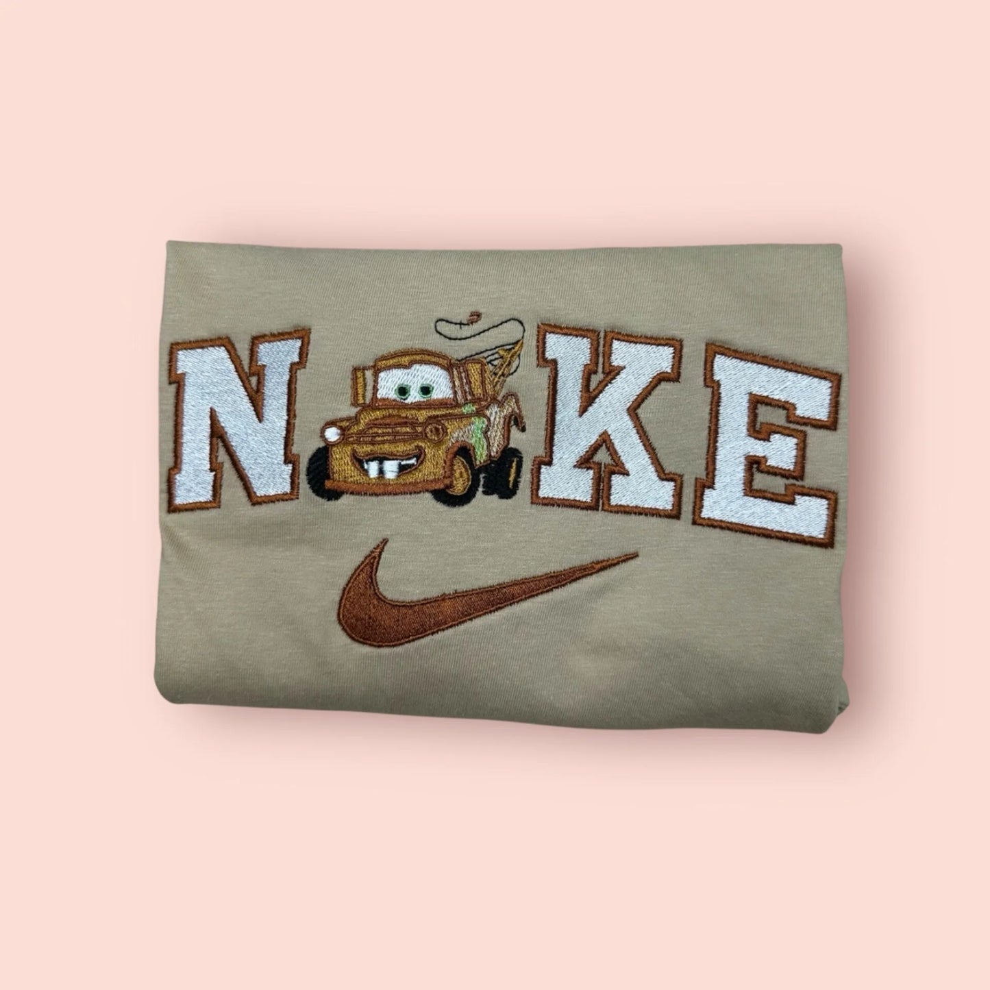 Sudadera de color beige arena (tono tierra) con un bordado muy detallado de Mate (Tow Mater), la grúa más querida de Cars. El diseño captura su expresión divertida y sus icónicos dientes, integrado en letras estilo vintage. Esta prenda personalizada es el regalo definitivo para ese "mejor amigo" leal y divertido. Compra online esta sudadera de Disney Pixar y combínala con la de Rayo McQueen para un look de "mejores amigos" inigualable.