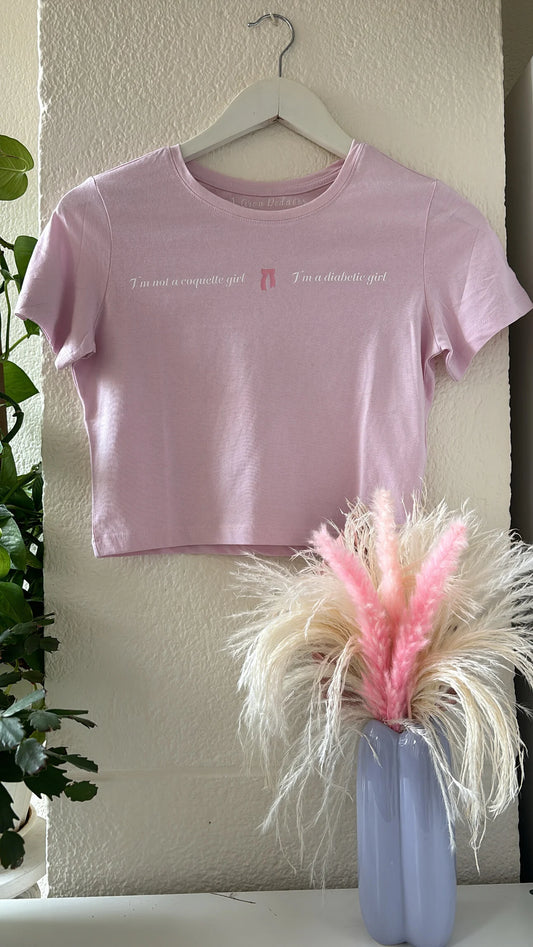camiseta cropped con la frase I'm not a coquette girl I'm a diabetic girl estampada en el pecho con un lazo