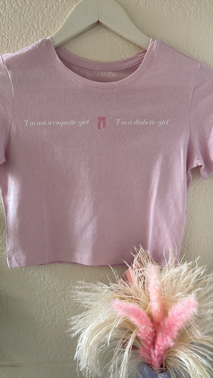camiseta cropped con la frase I'm not a coquette girl I'm a diabetic girl estampada en el pecho con un lazo
