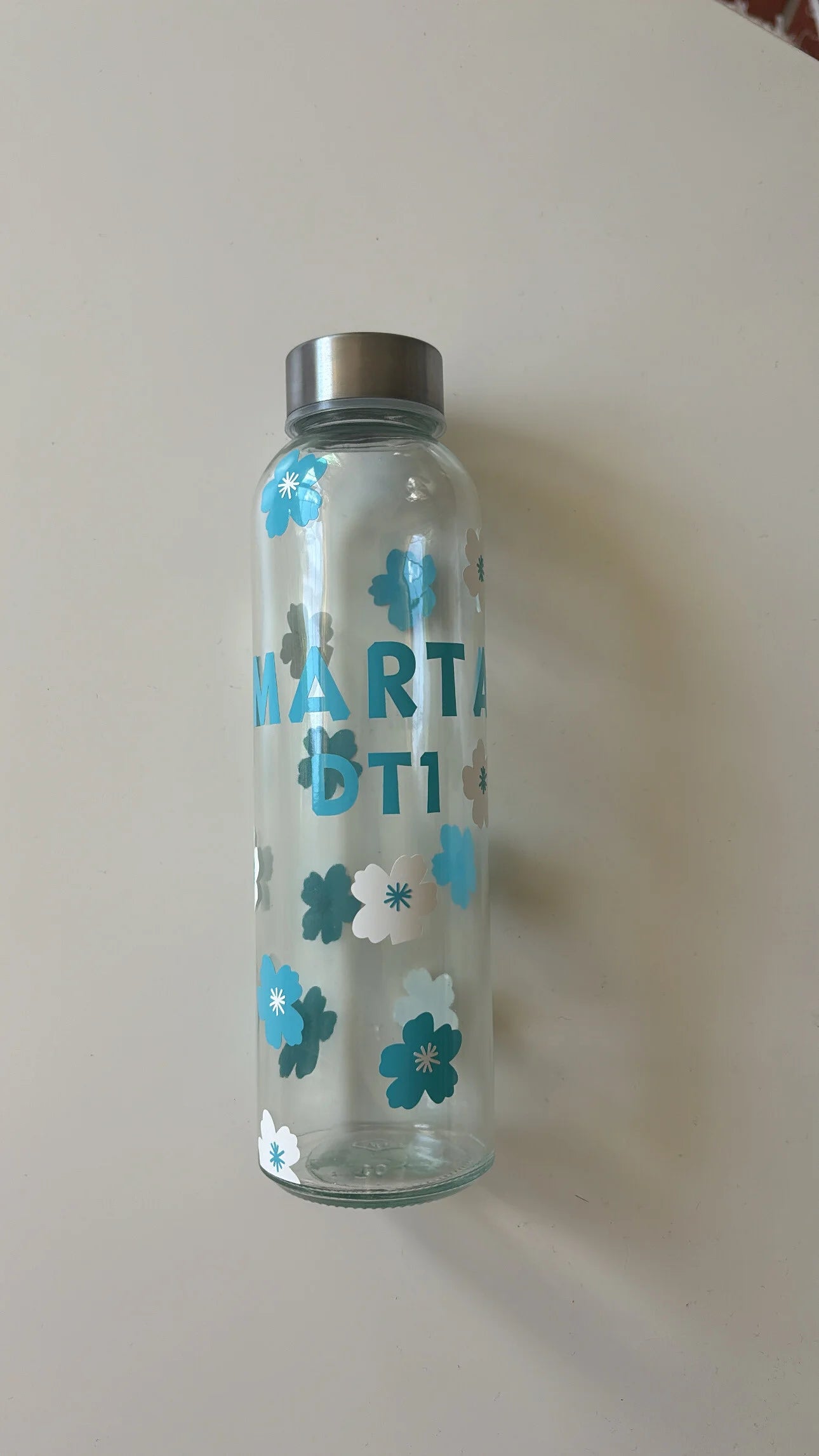 botella de cristal personalizada con flores, nombre y DT1 en el centro