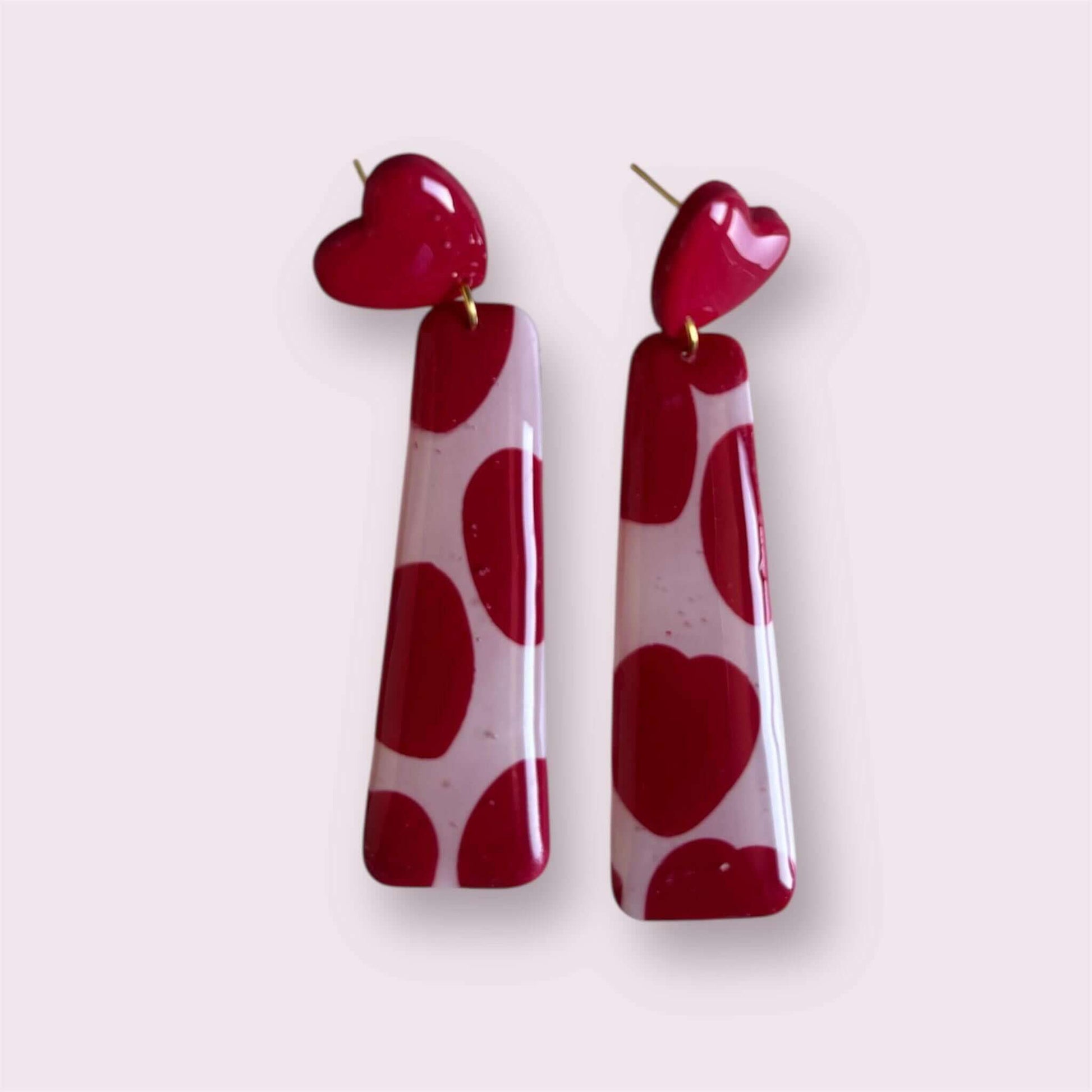 pendientes artesanales de arcilla polimérica con diseño rosa y corazones rojo

