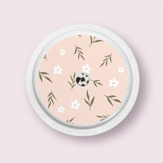 Sticker decorativo para sensor Freestyle 2 con flores blancas y hojas verdes sobre fondo rosa empolvado
