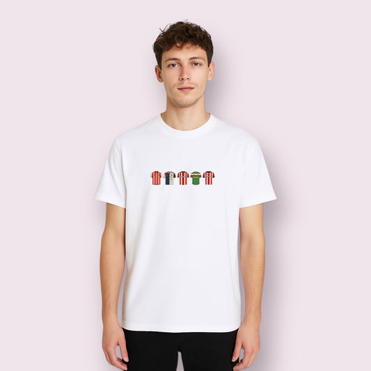 Joven con camiseta blanca de manga corta que luce un diseño centrado con efecto bordado DTF de camisetas históricas del Athletic Club de Bilbao. El estampado incluye seis equipaciones míticas del equipo vasco, representadas con detalles precisos que homenajean la evolución del club desde sus orígenes. Camiseta perfecta para fans del Athletic, ideal como regalo para futboleros, y confeccionada en algodón suave para máxima comodidad. Diseño exclusivo de Aroa Dedales pensado para unir estilo, historia y pasión