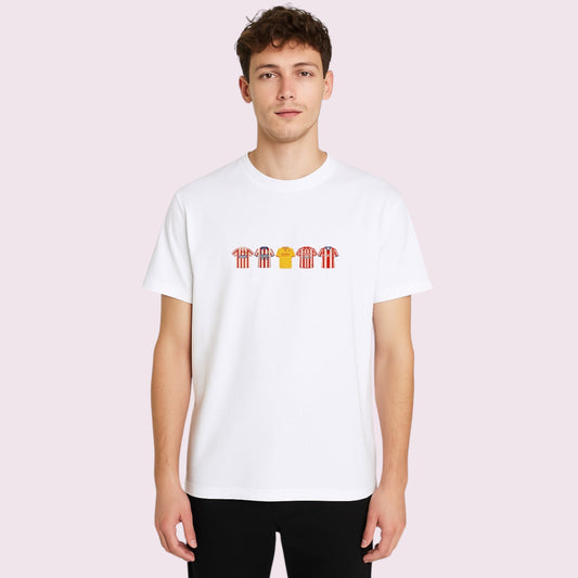 Vista detallada de la Camiseta Mareona Efecto Bordado sobre fondo neutro. Diseño exclusivo con ilustraciones bordadas de equipaciones míticas del Sporting de Gijón, incluyendo camisetas rojiblancas clásicas y camiseta amarilla icónica. Camiseta blanca 100% algodón, ideal para aficionados del fútbol español y seguidores del club asturiano. Producto personalizado con acabado en impresión DTF que imita el bordado. Ideal para regalo original a fans sportinguistas o para lucir en días de partido con orgullo gijo