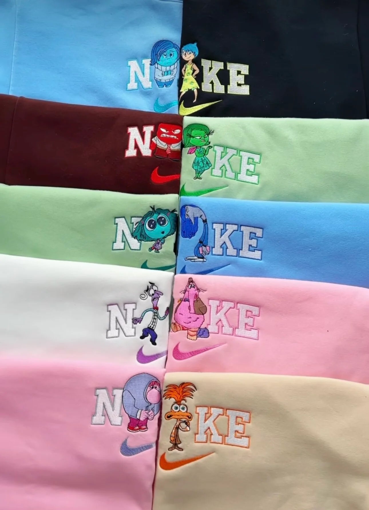 Pila de sudaderas bordadas de alta calidad inspiradas en la película Inside Out (Del Revés). La colección incluye todos los colores y personajes: Alegría, Tristeza, Ira, Asco, Miedo, Ansiedad, Envidia y Bing Bong. Diseño estilo deportivo con letras bordadas y el personaje sustituyendo la letra I. Ropa en tendencia ideal para regalo de grupo, parejas o para elegir tu emoción favorita. Disponibles en azul, rojo, verde, rosa y beige.