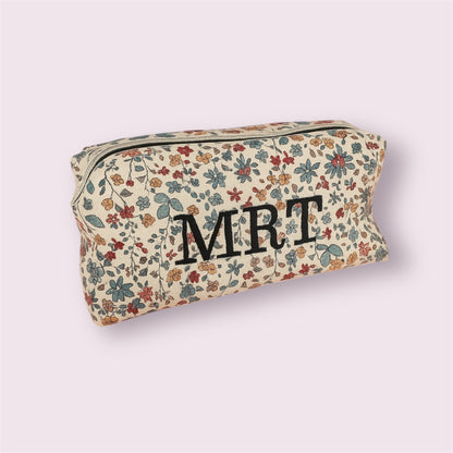 Neceser cuadrado pequeño con estampado floral e iniciales MRT bordadas en negro, diseño artesanal de Aroa Dedales
