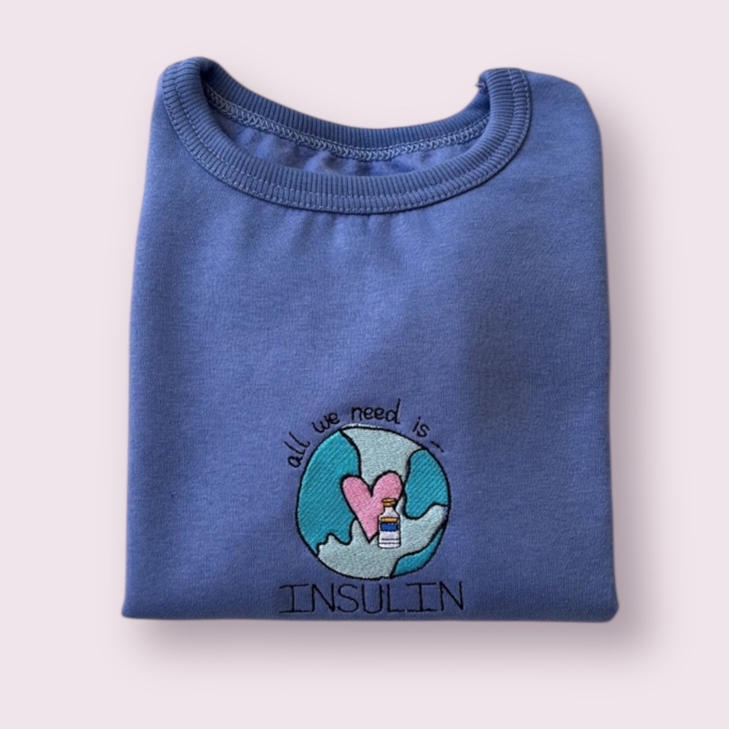 Sudadera infantil azul para niñas y niños con diseño bordado "All we need is insulin", ideal para visibilizar la diabetes tipo 1 con un mensaje positivo y tierno. Prenda cómoda, personalizada y pensada para peques con diabetes