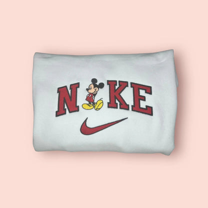 Sudadera blanca con bordado de alta definición de Mickey Mouse, el ratón más famoso del mundo. Diseño retro con el personaje en su pose clásica sobre letras rojas estilo varsity. Prenda unisex de algodón suave, ideal para fans de Disney de todas las edades. Compra esta sudadera junto a la de Minnie para crear el look perfecto de parejas para vuestra próxima visita a Disneyland o Walt Disney World