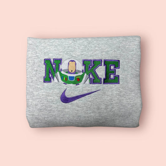 Sudadera gris jaspeado con bordado premium de Buzz Lightyear. El diseño integra el traje del Guardián Espacial con los colores verde y morado característicos sobre letras estilo varsity. Sudadera personalizada de Toy Story perfecta para hombre o unisex. Ideal para combinar en pareja junto con el modelo de Bo Peep (matching outfits). Llevamos tu estilo "hasta el infinito y más allá" con esta edición coleccionista.