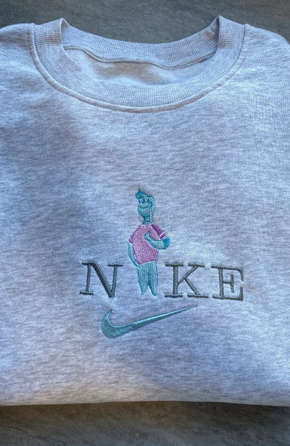 Sudadera gris jaspeado con un bordado detallado de Nilo (Wade Ripple) de la película Elementos. El diseño captura al sensible personaje de agua con sus tonos turquesa y rosa, integrado en el logo. Prenda de Pixar perfecta para regalar a novios o para crear el conjunto de pareja más original. La pieza que completa el dúo "Fuego y Agua" con la sudadera de Candela.