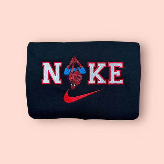 Sudadera negra de alta calidad con un bordado detallado de Spider-Man colgado boca abajo. El diseño clásico del superhéroe de Marvel se integra perfectamente en el logo con letras rojas y blancas. Prenda de estilo urbano y atemporal, ideal para cualquier fan de los cómics. La pieza esencial para completar el dúo con la sudadera de Spider-Gwen.