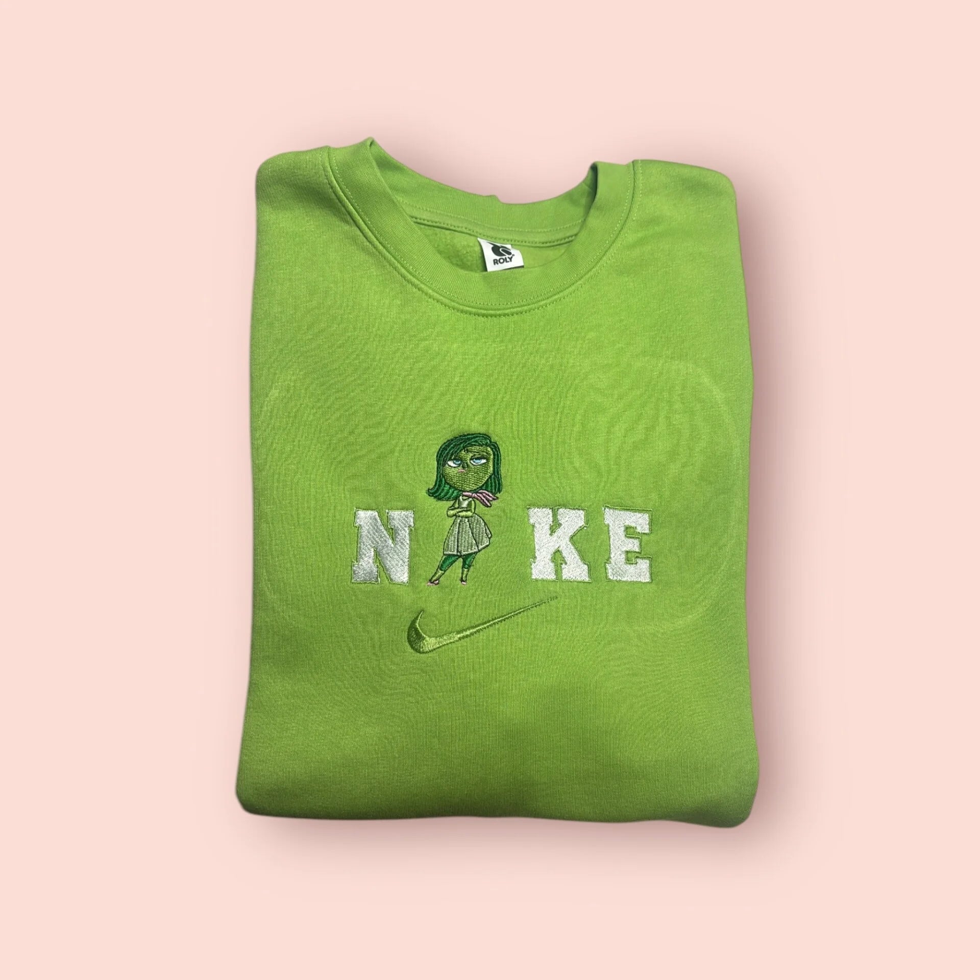 Sudadera de color verde pistacho con bordado detallado de Asco (Disgust) de Inside Out. El personaje posa con actitud sobre el logo en letras blancas. Prenda estilo aesthetic perfecta para combinar con outfits coloridos. Sudadera personalizada de máxima calidad, suave al tacto y duradera. El regalo perfecto para esa amiga con estilo y personalidad.