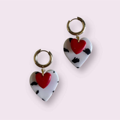 pendientes de arcilla polimérica con corazón rojo y estampado blanco y negro sobre fondo rosa