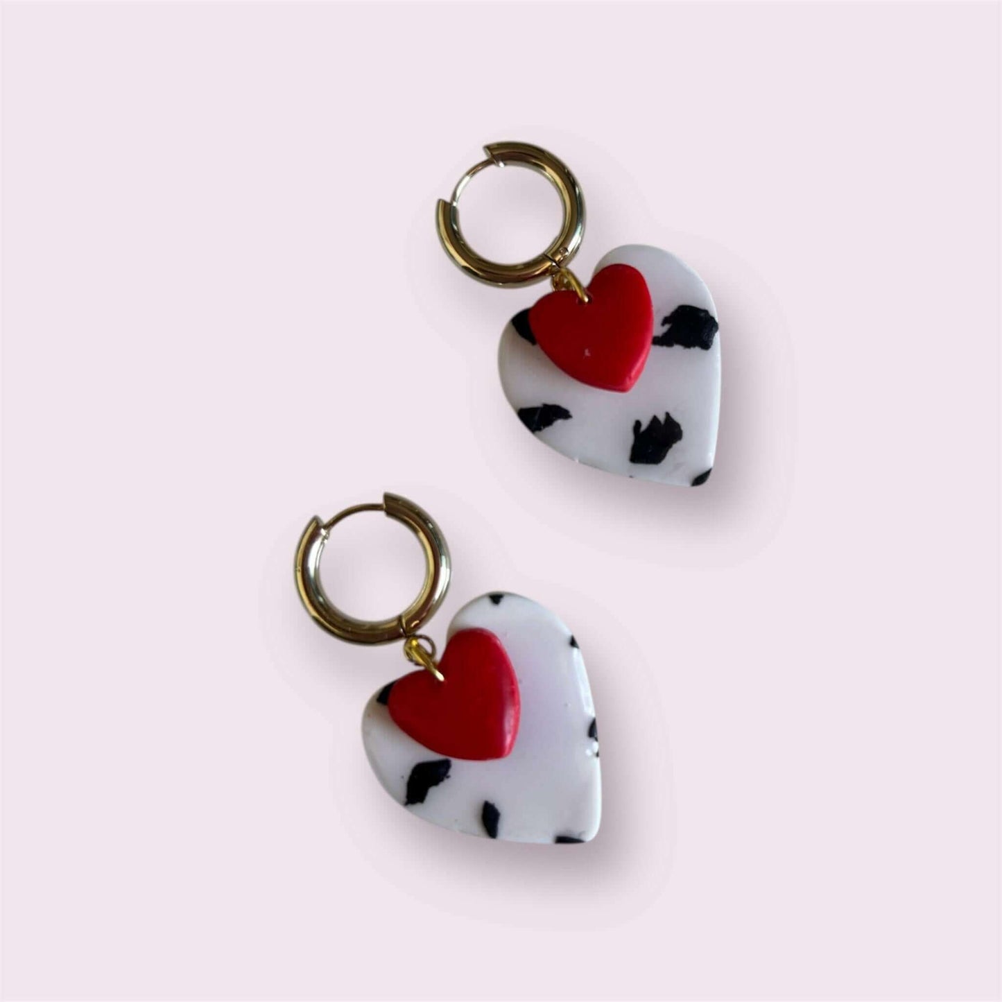 pendientes de arcilla polimérica con corazón rojo y estampado blanco y negro sobre fondo rosa