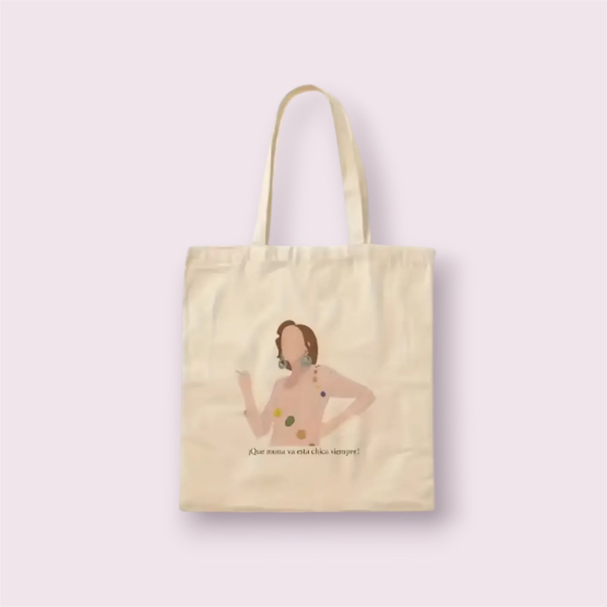 Tote bag de algodón natural con ilustración y frase icónica 'Qué mona va esta chica siempre', inspirada en la serie Aquí no hay quien viva. Diseño divertido y nostálgico ideal como regalo original para fans de la televisión española, hecha a mano en España con materiales sostenibles. Bolsa resistente, reutilizable y con mucho estilo para uso diario, compras o escapadas. Complemento eco-friendly perfecto para quienes aman la moda con guiños culturales y sentido del humor.